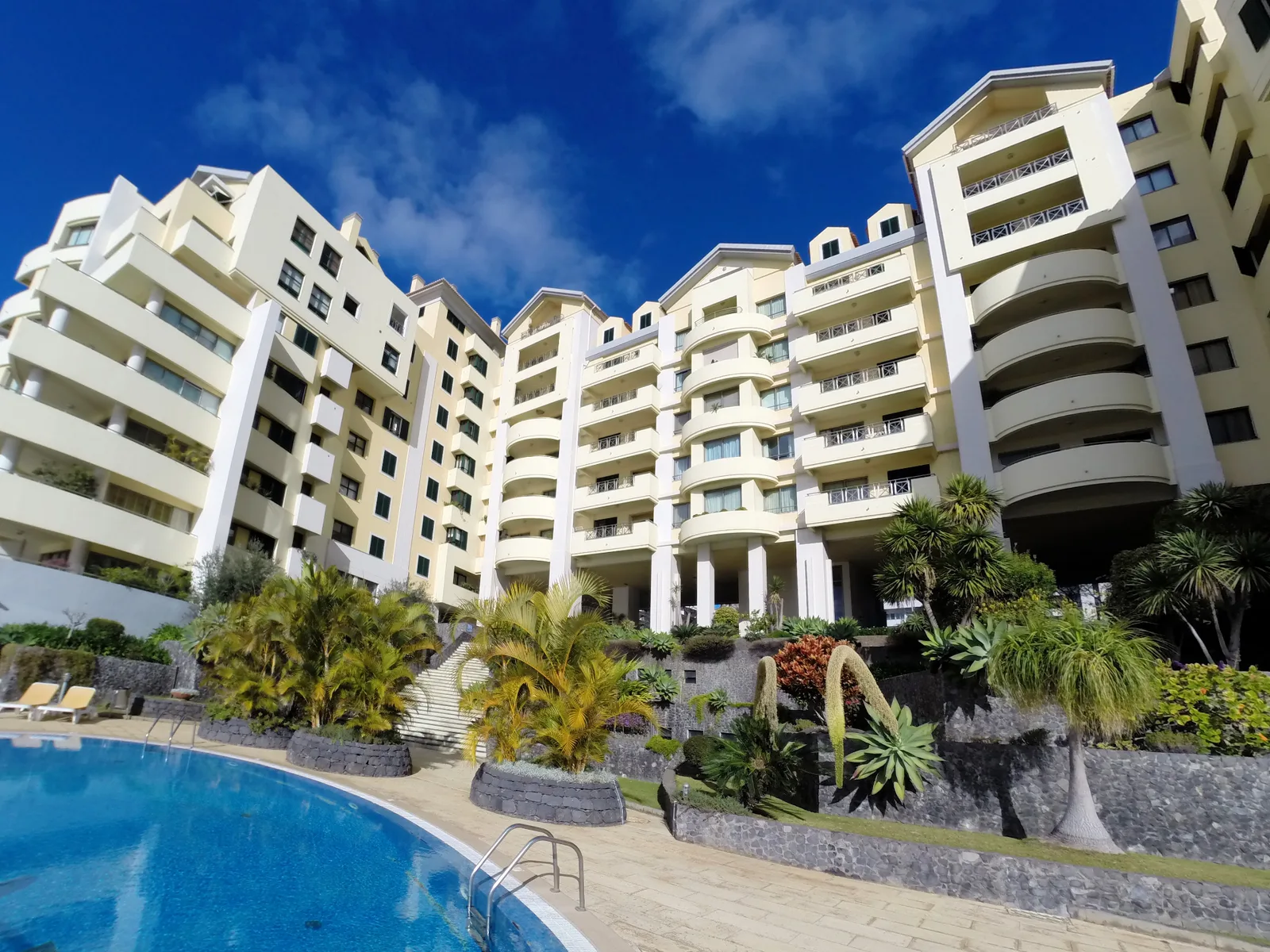 Apartment complex with large swimming pool and blue sky
