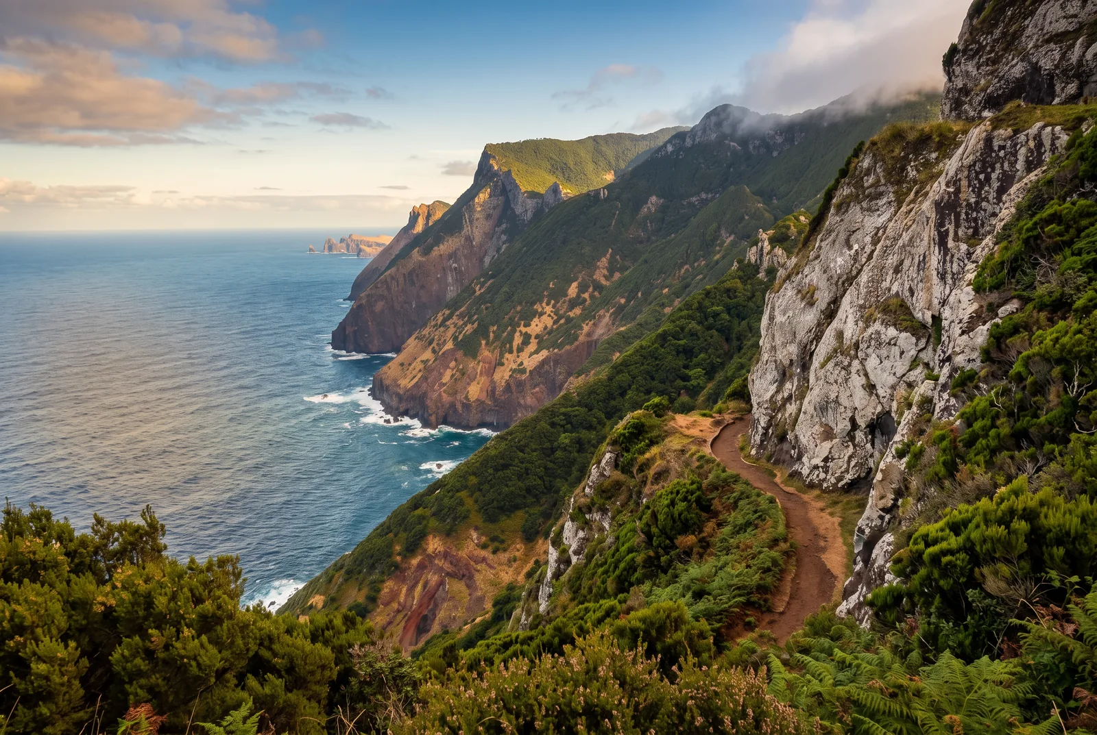Sea cliffs receding along the wild north coast seen from a narrow clifftop path