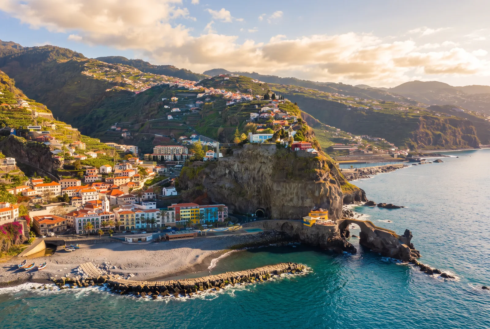 A south coast village with a pebble beach, headland and old stone quay at golden hour