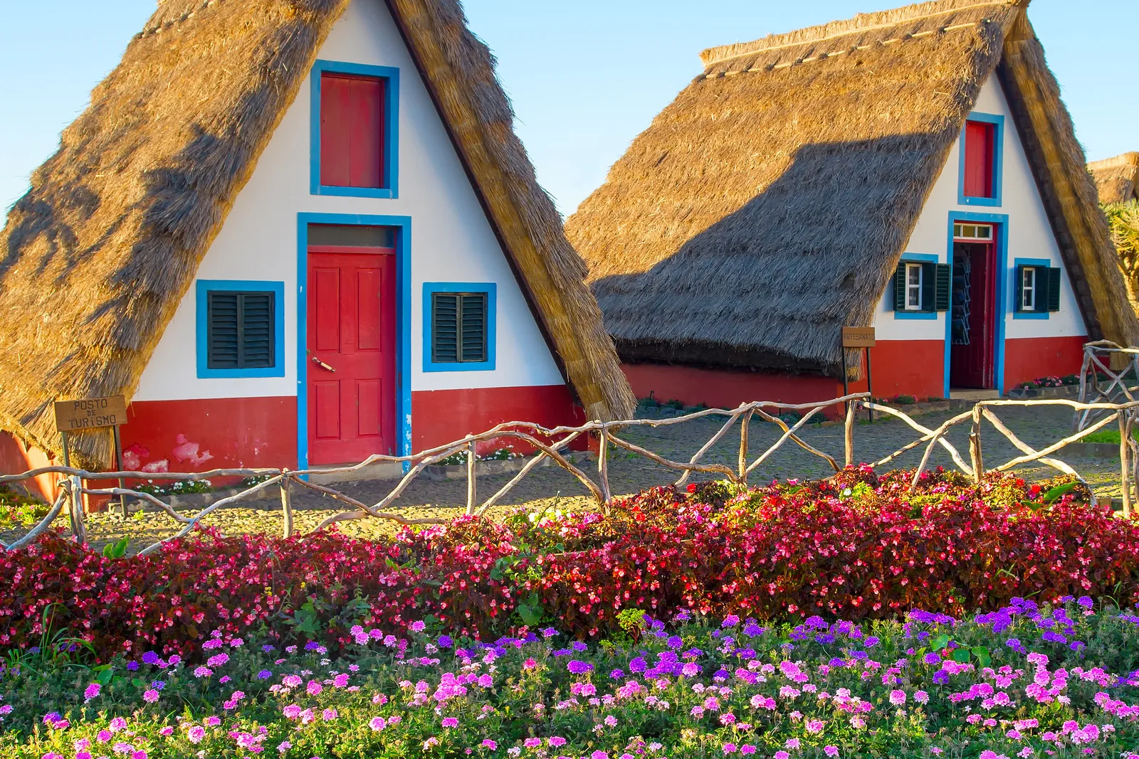 Triangular thatched Santana houses with red doors and blue window frames