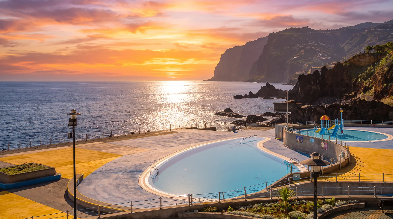 The Ponta Gorda bathing complex at sunset with the sun low over the Atlantic