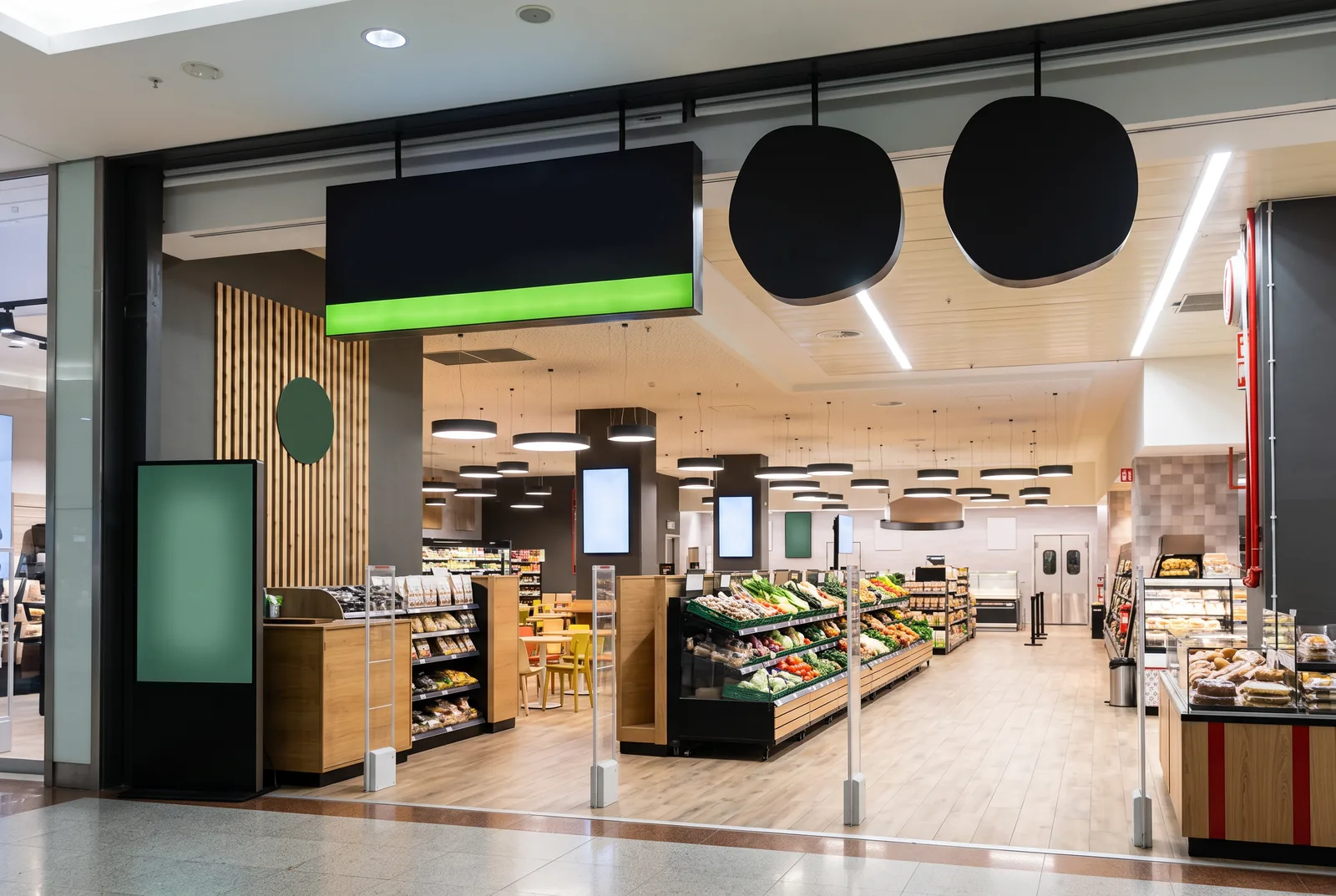 The supermarket entrance inside Fórum Madeira seen from the mall gallery, with produce and bakery beyond