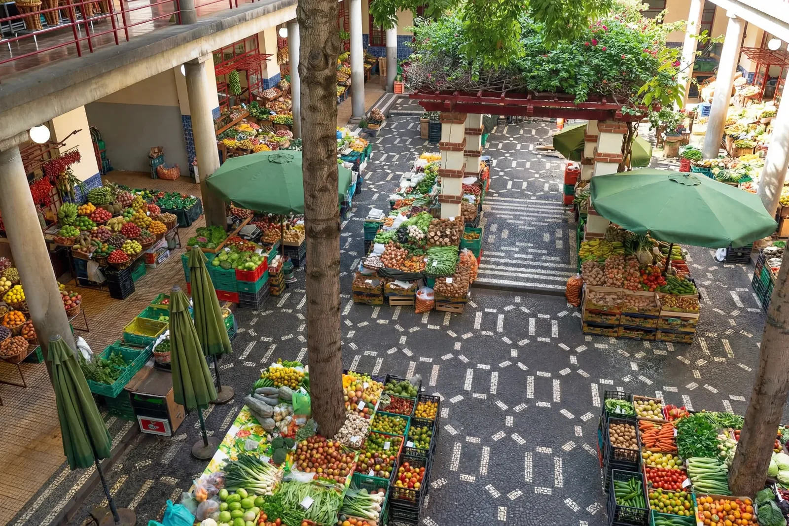 The tiled inner courtyard of Mercado dos Lavradores seen from the upper gallery, with fruit stalls below