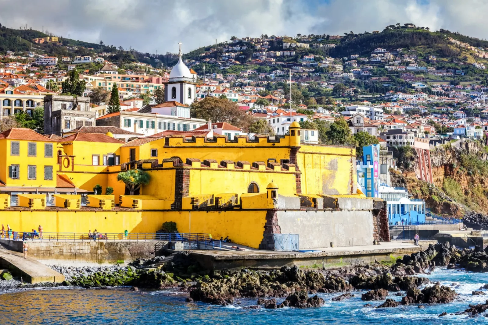 The yellow Forte de São Tiago on the Funchal seafront with the old town and the hillside behind