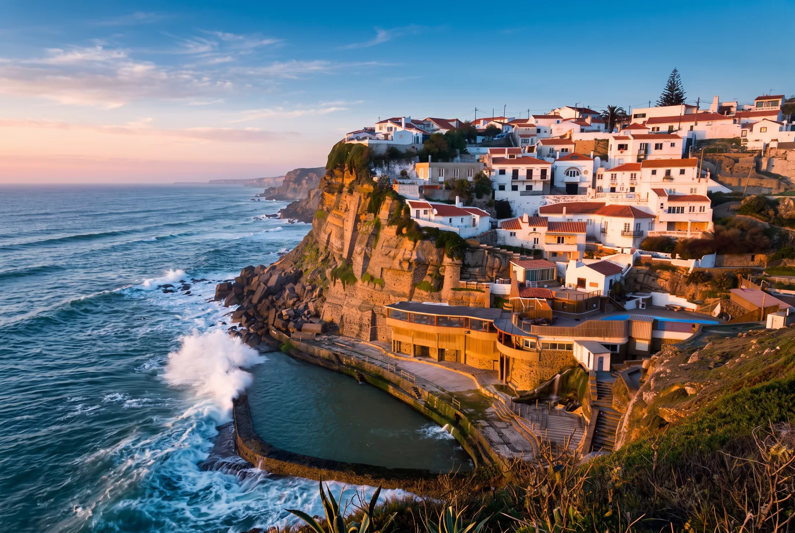 The white village of Azenhas do Mar stacked on its cliff above the Atlantic, with the sea pool below