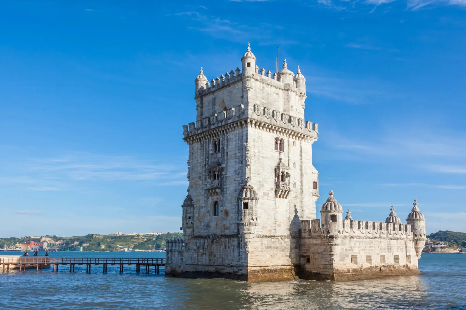 Torre de Belém standing in the Tagus under a clear sky