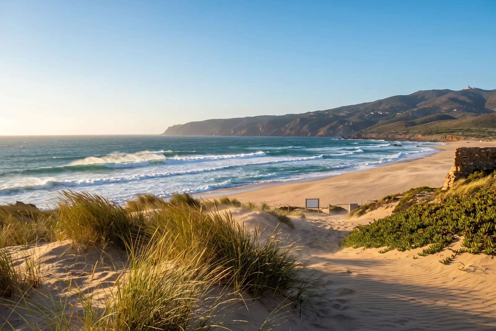 The wide windswept sand of Praia do Guincho with the Serra de Sintra behind