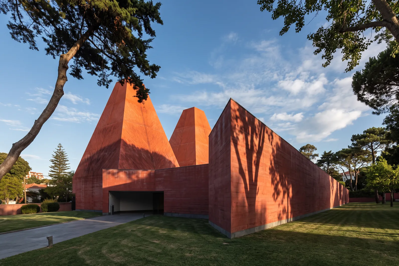 The red concrete volumes and pyramid towers of the Casa das Historias Paula Rego seen from the side