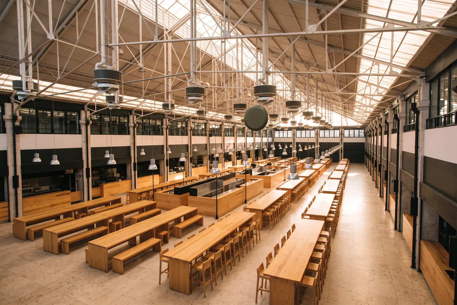The iron-roofed hall of Time Out Market before opening, communal tables empty
