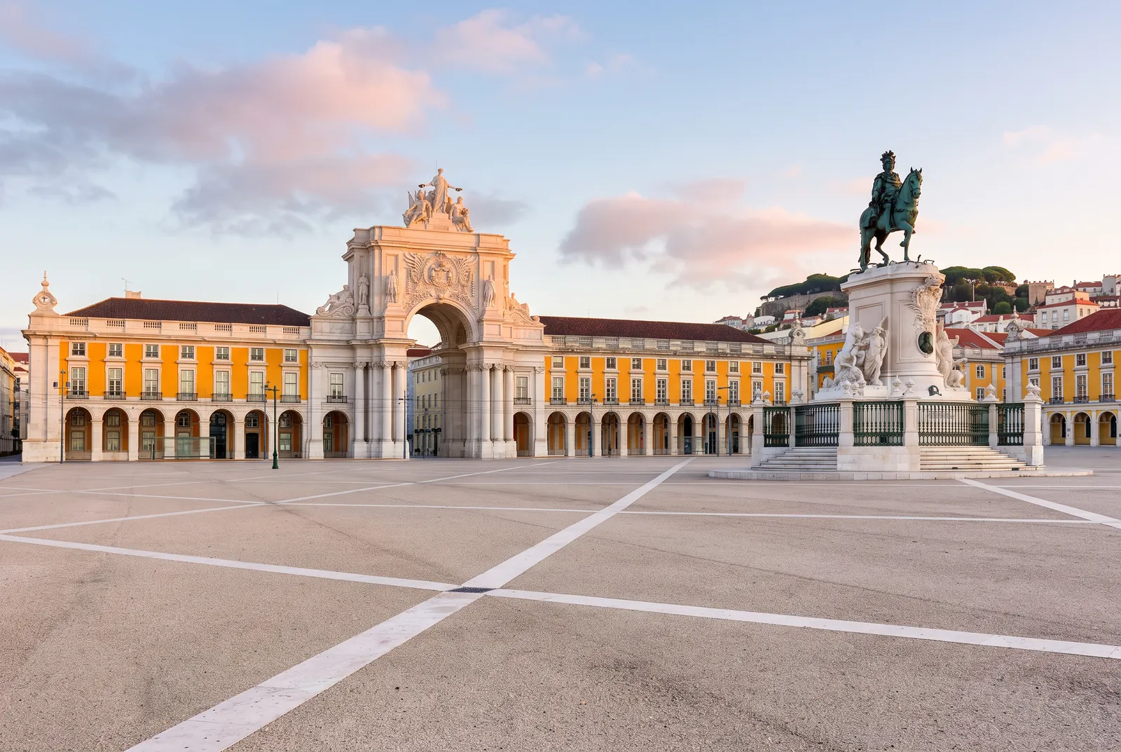 The Cais das Colunas steps and columns at sunrise, with Praça do Comércio and the Arco da Rua Augusta behind