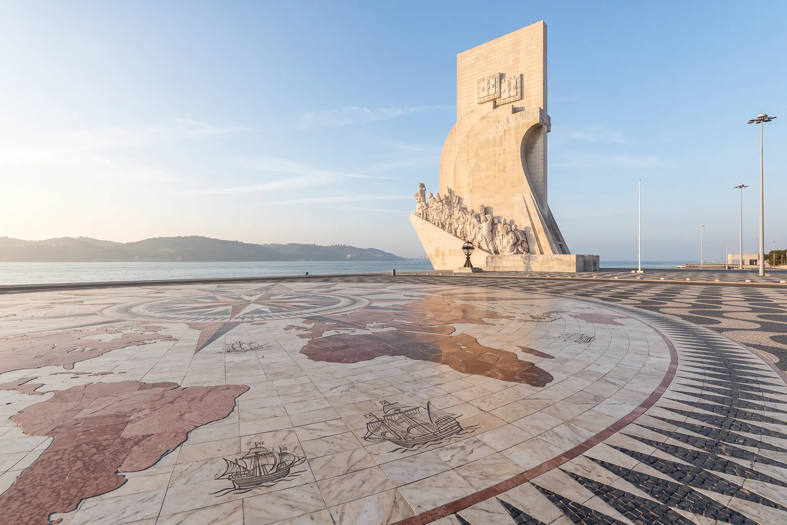 The Monument to the Discoveries in early-morning light, seen from the marble compass rose and world map in the pavement