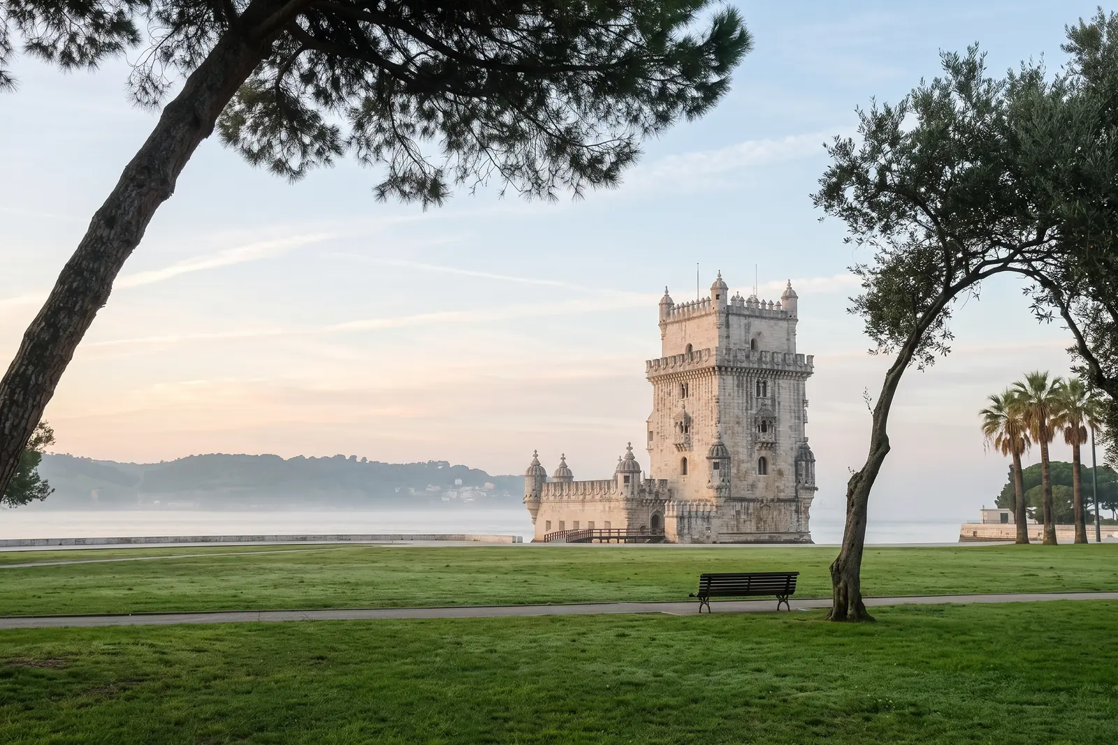 Belém Tower across the empty lawns of the Jardim da Torre de Belém on a hazy morning